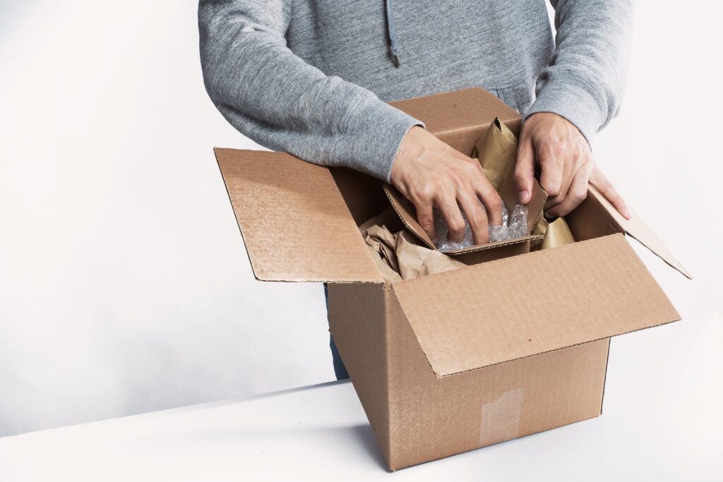 a person is preparing and packaging a product in a cardboard box. Ready for delivery. 